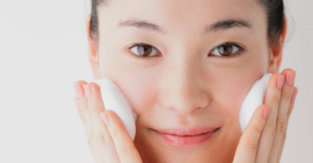 両方のほほにホイップ泡をあてている女性のアップ