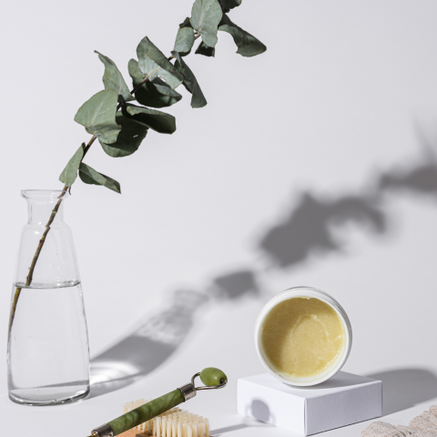 夏の日差しのようなリーフの影が背景に映る化粧品のイメージ